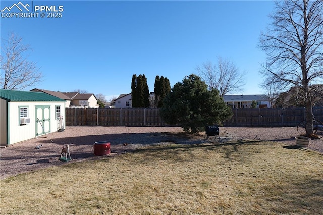 view of yard featuring a fenced backyard, a residential view, and an outdoor structure