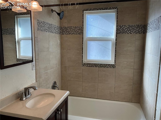 bathroom featuring vanity, a wealth of natural light, and tiled shower / bath