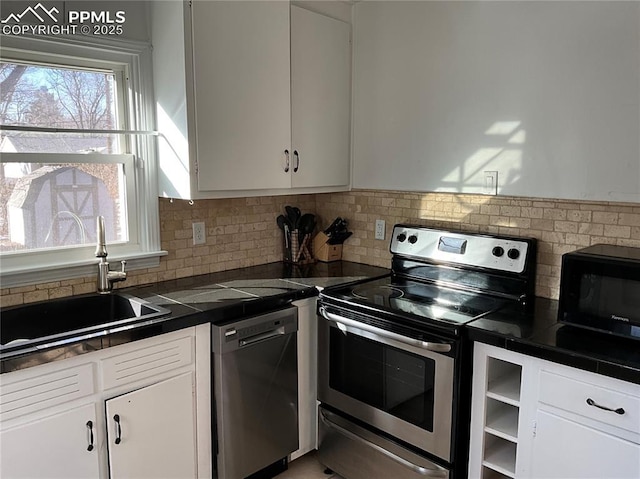 kitchen featuring tasteful backsplash, sink, white cabinets, and appliances with stainless steel finishes