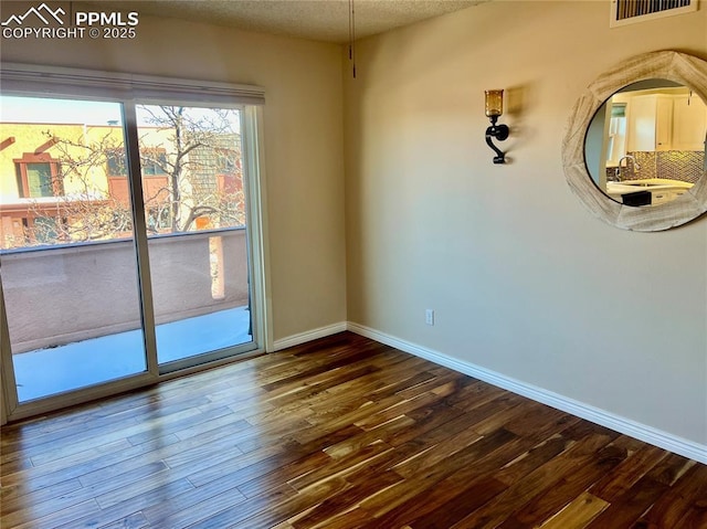 unfurnished room with sink and hardwood / wood-style floors