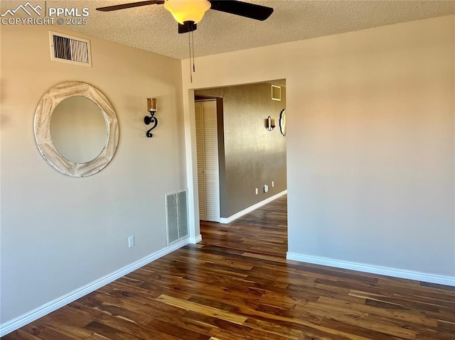 unfurnished room with ceiling fan, dark hardwood / wood-style floors, and a textured ceiling