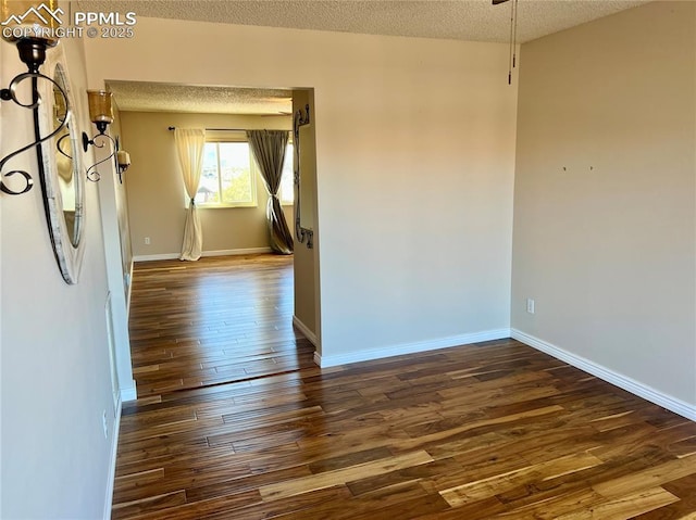 empty room featuring dark wood-type flooring and a textured ceiling