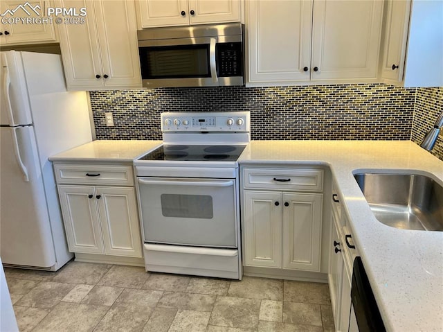 kitchen featuring white cabinetry, sink, decorative backsplash, light stone countertops, and white appliances