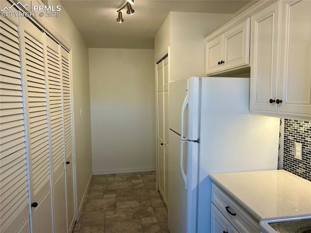 kitchen with backsplash, white refrigerator, range, and white cabinets