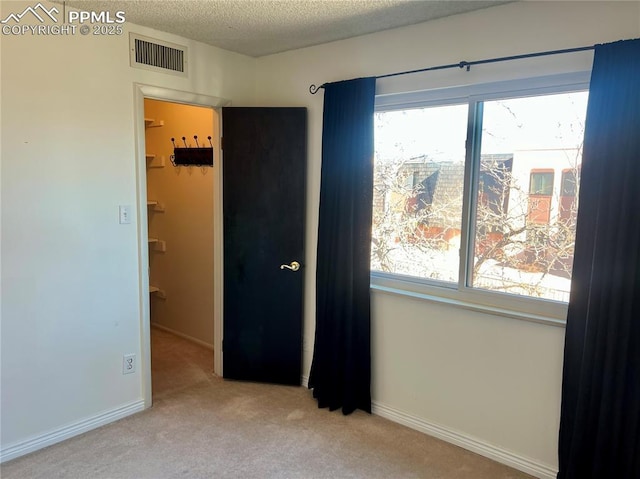 carpeted spare room featuring a textured ceiling