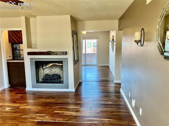 corridor with dark hardwood / wood-style floors and a textured ceiling