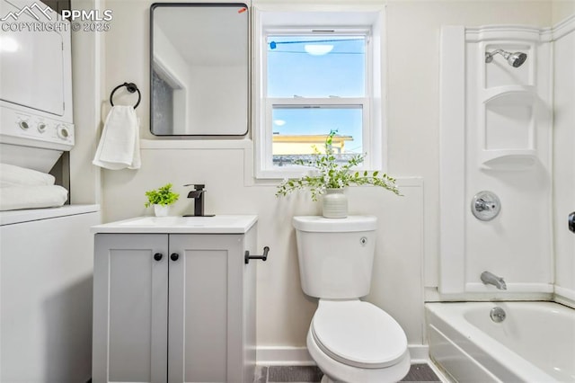 full bathroom with stacked washing maching and dryer, shower / bathing tub combination, vanity, and toilet