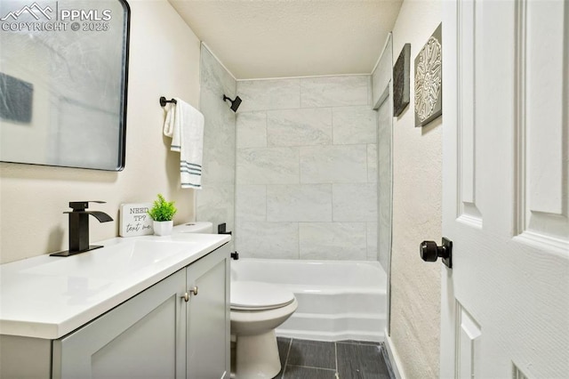 full bathroom featuring tiled shower / bath combo, vanity, and toilet