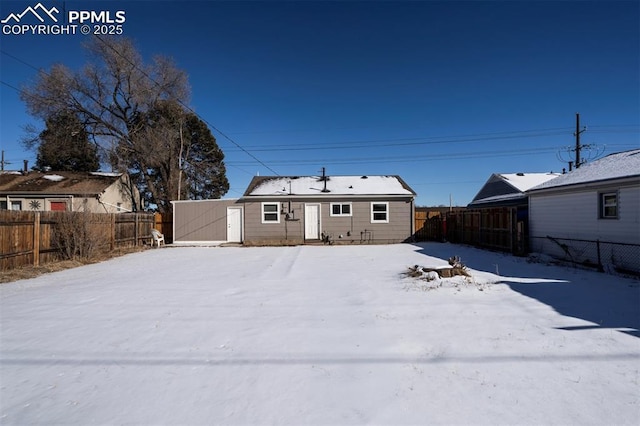 view of snow covered back of property