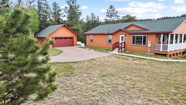 view of front of property featuring a garage, an outdoor structure, and a front lawn