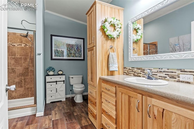 bathroom with toilet, crown molding, wood-type flooring, vanity, and decorative backsplash