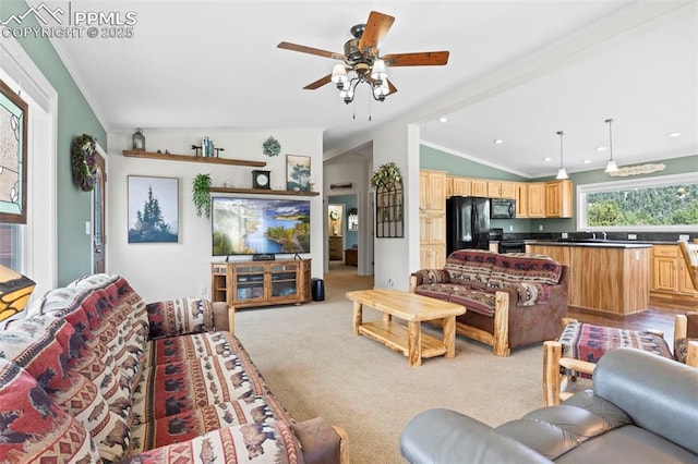 living room with lofted ceiling, sink, light colored carpet, ceiling fan, and crown molding