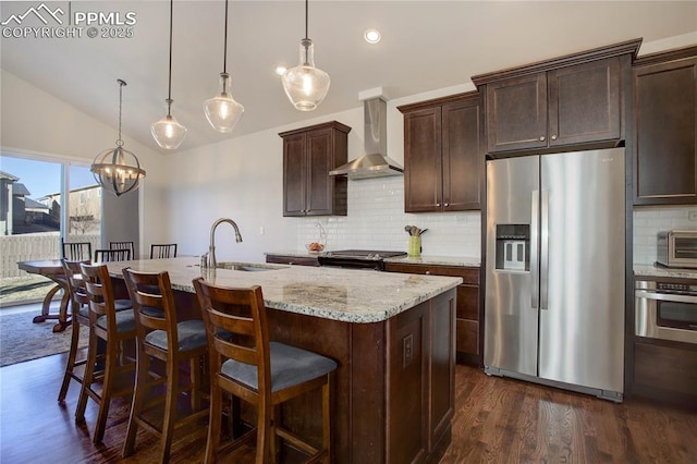 kitchen featuring lofted ceiling, dark wood-style flooring, a sink, appliances with stainless steel finishes, and wall chimney exhaust hood