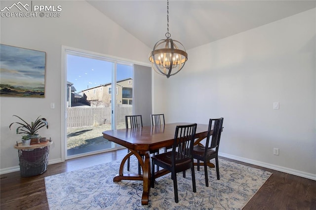 dining space featuring a notable chandelier, vaulted ceiling, baseboards, and wood finished floors