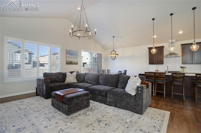 living room with high vaulted ceiling, recessed lighting, a notable chandelier, baseboards, and dark wood finished floors