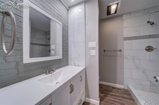 bathroom with vanity, hardwood / wood-style floors, and a tile shower