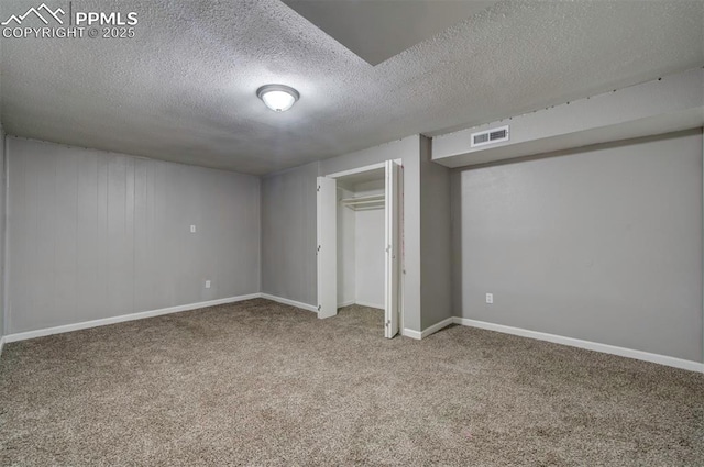 basement featuring carpet floors and a textured ceiling