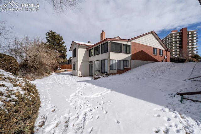 view of snow covered back of property