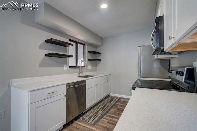 kitchen with appliances with stainless steel finishes, sink, white cabinets, and dark hardwood / wood-style floors