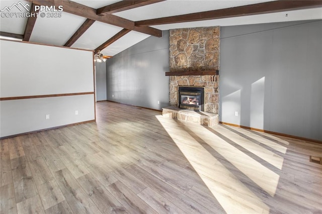 unfurnished living room featuring ceiling fan, vaulted ceiling with beams, a fireplace, and light hardwood / wood-style flooring