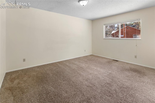 carpeted spare room featuring a textured ceiling