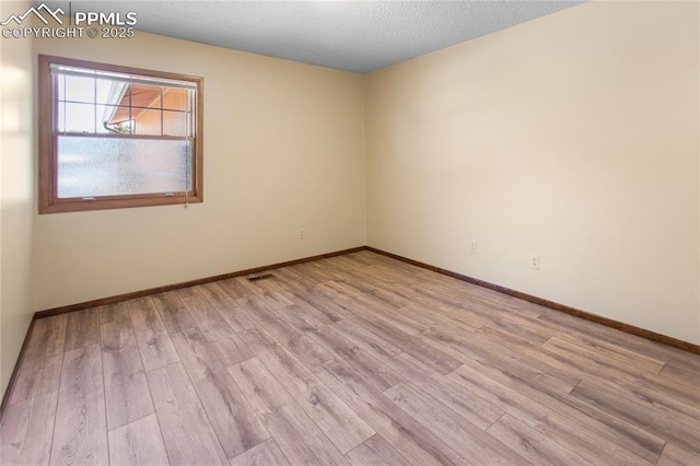 empty room with light hardwood / wood-style flooring