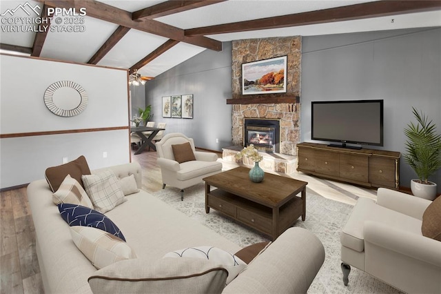 living room featuring a fireplace, light hardwood / wood-style flooring, and lofted ceiling with beams