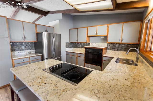 kitchen featuring lofted ceiling with beams, sink, tasteful backsplash, and black appliances