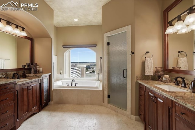 bathroom featuring vanity and independent shower and bath