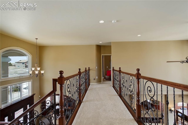 hall with light carpet and a notable chandelier