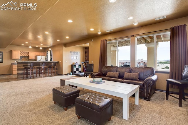 carpeted living room featuring a textured ceiling