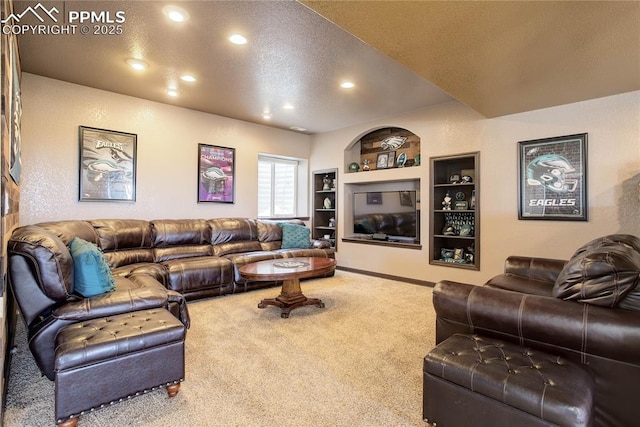 carpeted living room featuring built in shelves and a textured ceiling