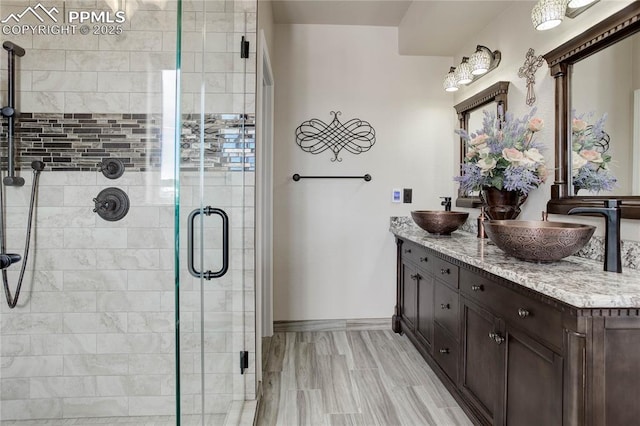 bathroom with vanity and a shower with door