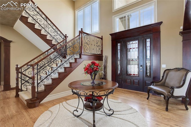 entrance foyer with light hardwood / wood-style floors and a high ceiling