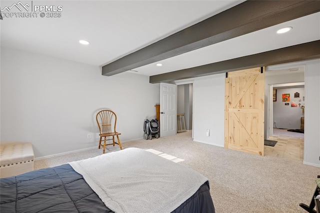 carpeted bedroom with a barn door and beamed ceiling