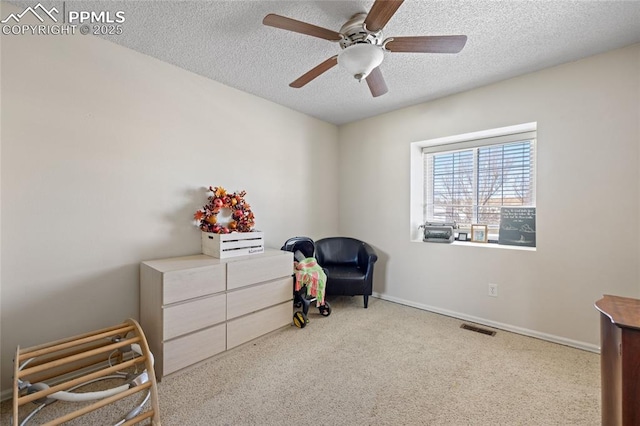 sitting room with light carpet, ceiling fan, and a textured ceiling