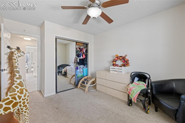 carpeted bedroom with ceiling fan, a closet, and a textured ceiling