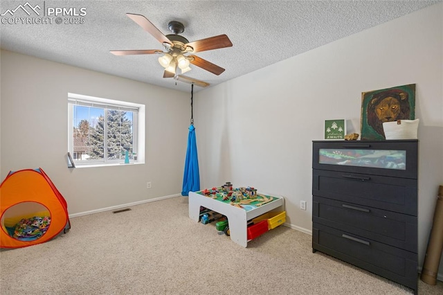 game room featuring ceiling fan, light carpet, and a textured ceiling