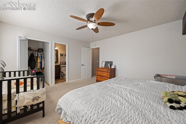 bedroom with a spacious closet, light colored carpet, ceiling fan, ensuite bath, and a closet