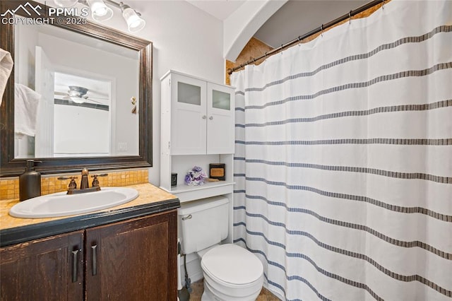 bathroom with vanity, backsplash, and toilet