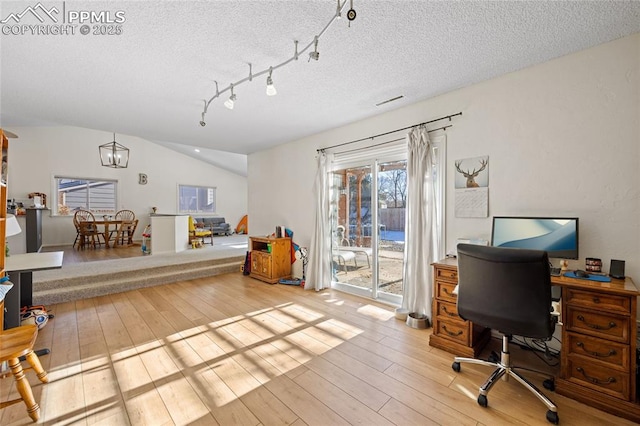 home office with lofted ceiling, a chandelier, light hardwood / wood-style floors, and a textured ceiling