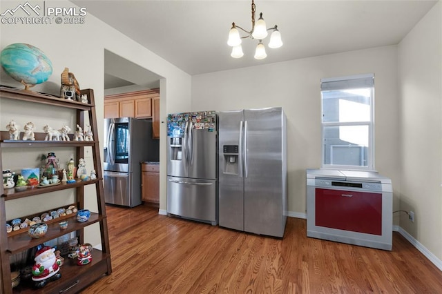 kitchen featuring stainless steel fridge with ice dispenser, light wood-type flooring, and light brown cabinets