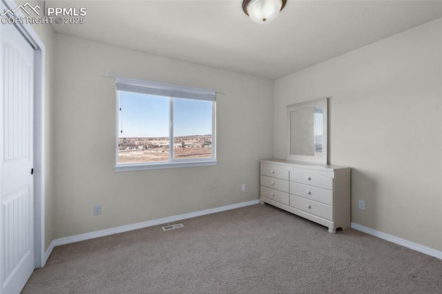 unfurnished bedroom featuring light carpet and a closet