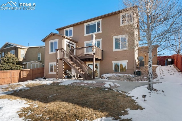 snow covered rear of property featuring a wooden deck