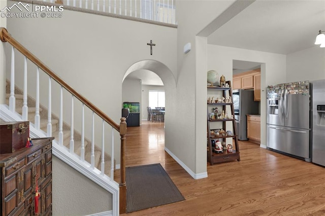 foyer featuring hardwood / wood-style flooring and a towering ceiling