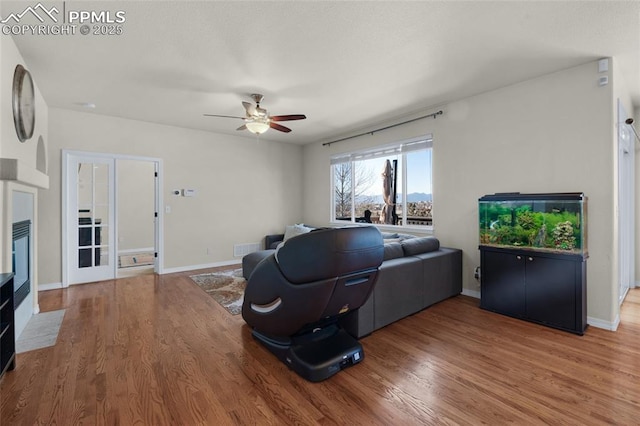 living room featuring ceiling fan and hardwood / wood-style floors