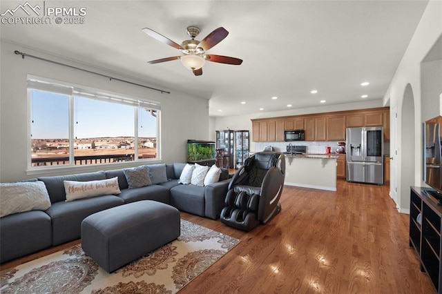 living room featuring ceiling fan, wood-type flooring, and sink