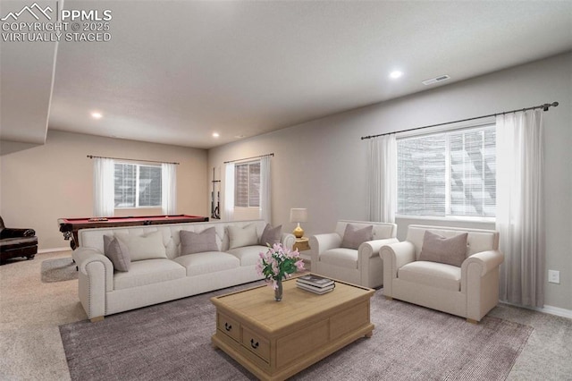 living area featuring recessed lighting, baseboards, visible vents, and light carpet