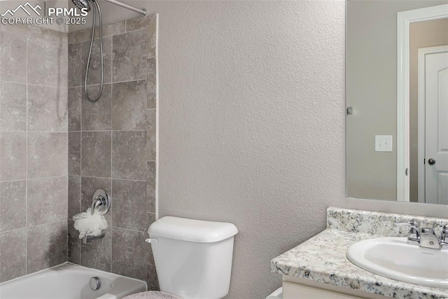 full bath featuring toilet, a textured wall, shower / washtub combination, and vanity