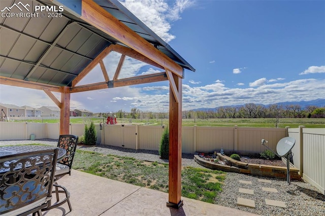 view of patio featuring a gate, a mountain view, and a fenced backyard